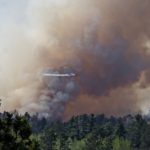 Aircraft flying in heavy smoke over the forest.