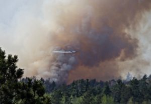 Aircraft flying in heavy smoke over the forest.