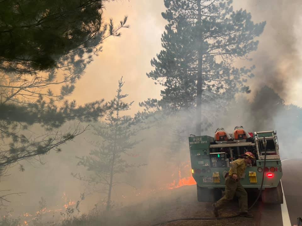 Smoke fills air with orange flames and a fire engine.