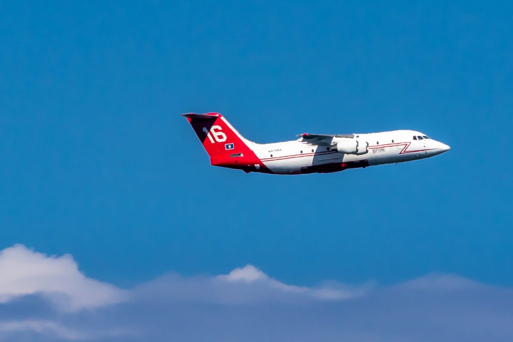 Aircraft flying next to a blue sky with white clouds