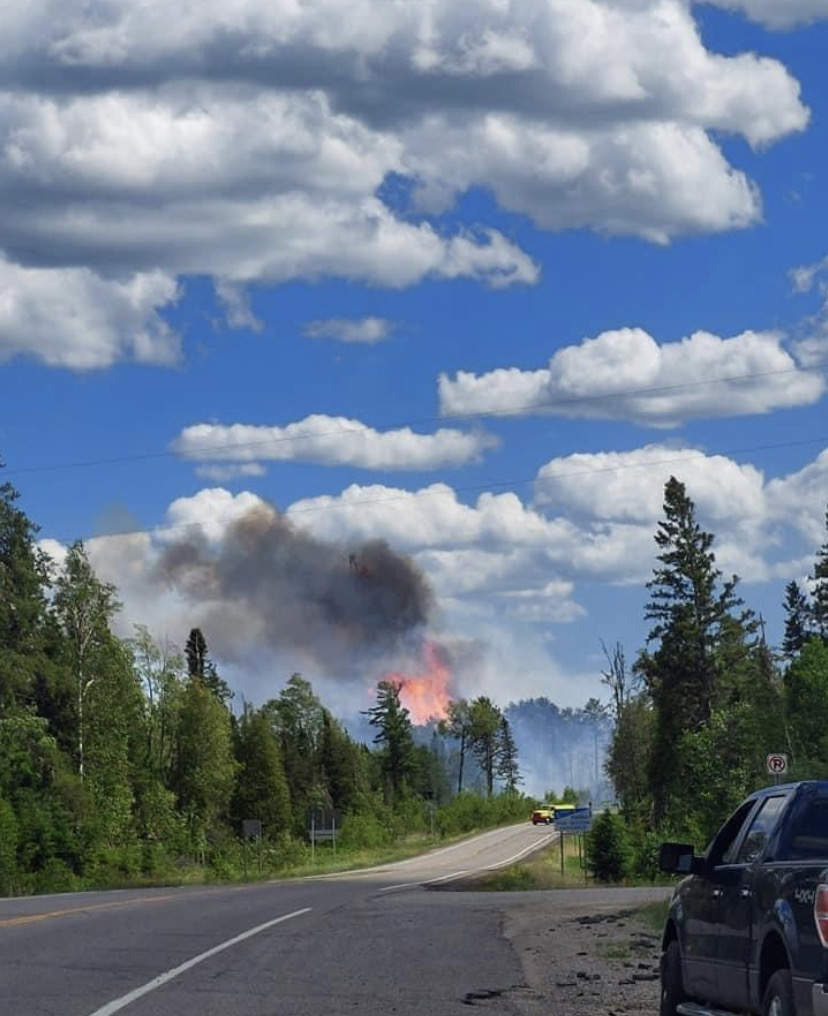 Forest fire flames with road and blue sky.