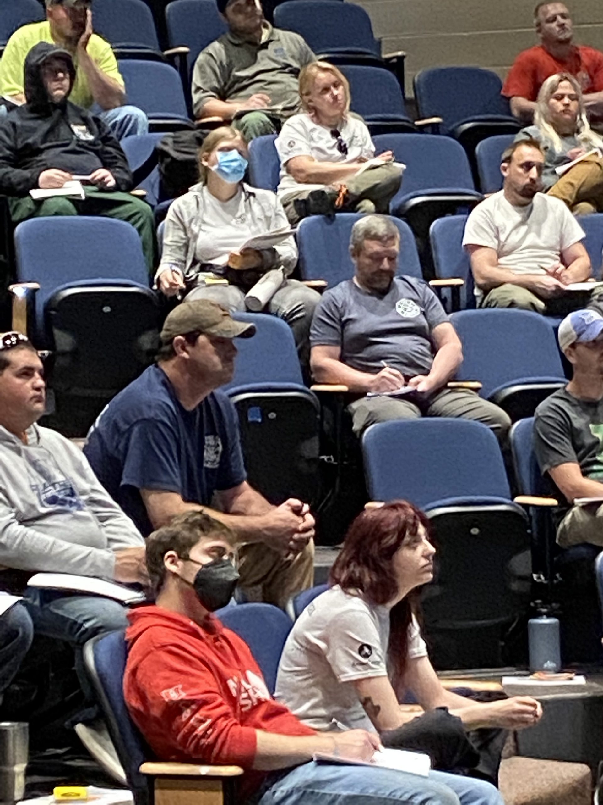 Student sitting in stadium seat some wearing masks.