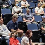 Students sit in lecture hall seats.