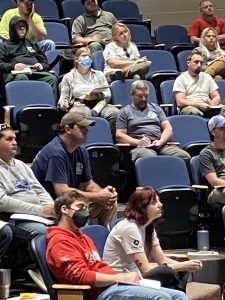 Students sit in lecture hall seats.