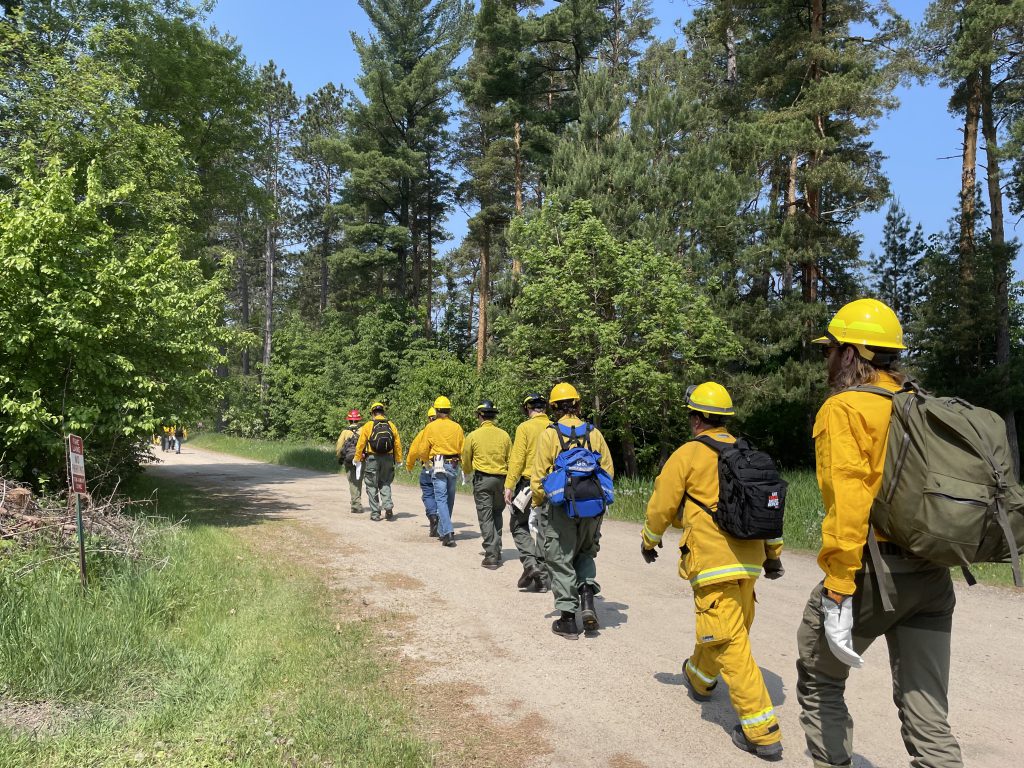 Wildfire Academy students in a line walking on a dirt path