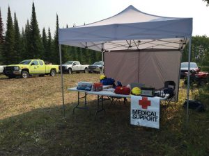 Tent with supplies near trucks.