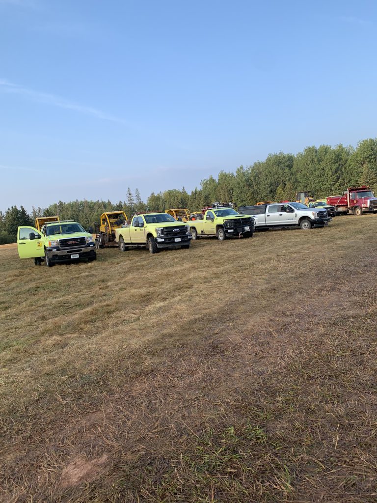 A line of vehicles parked at the staging area on Cty Rd 11