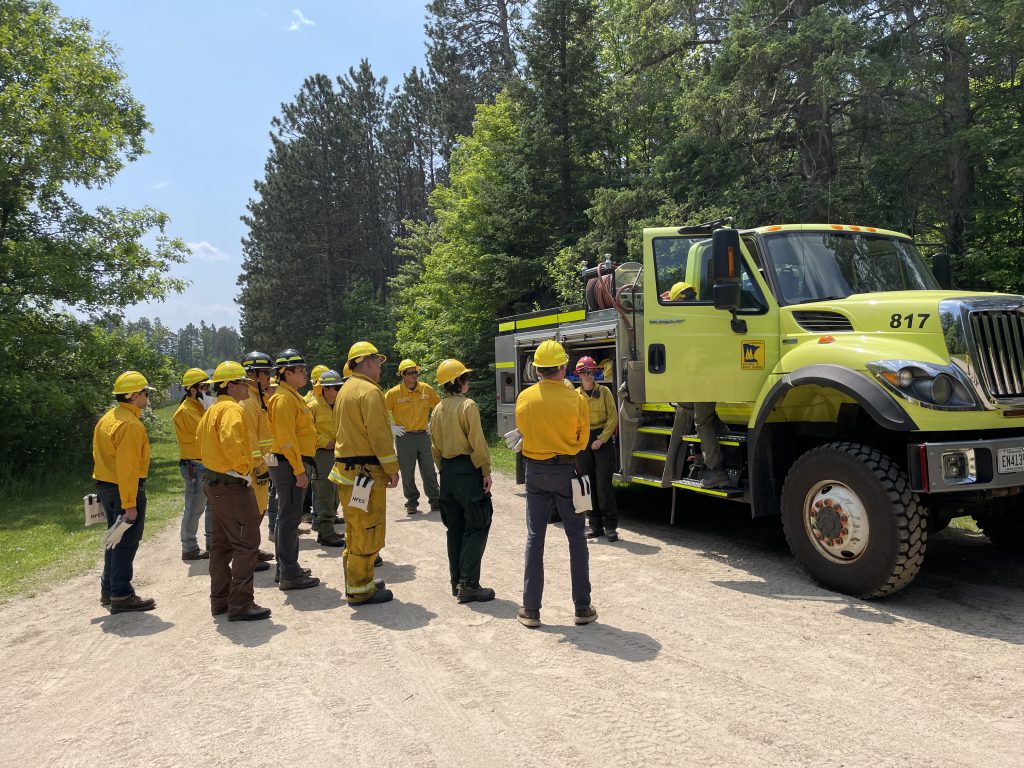 A group of Fire Academy students standing in front of a fire engine