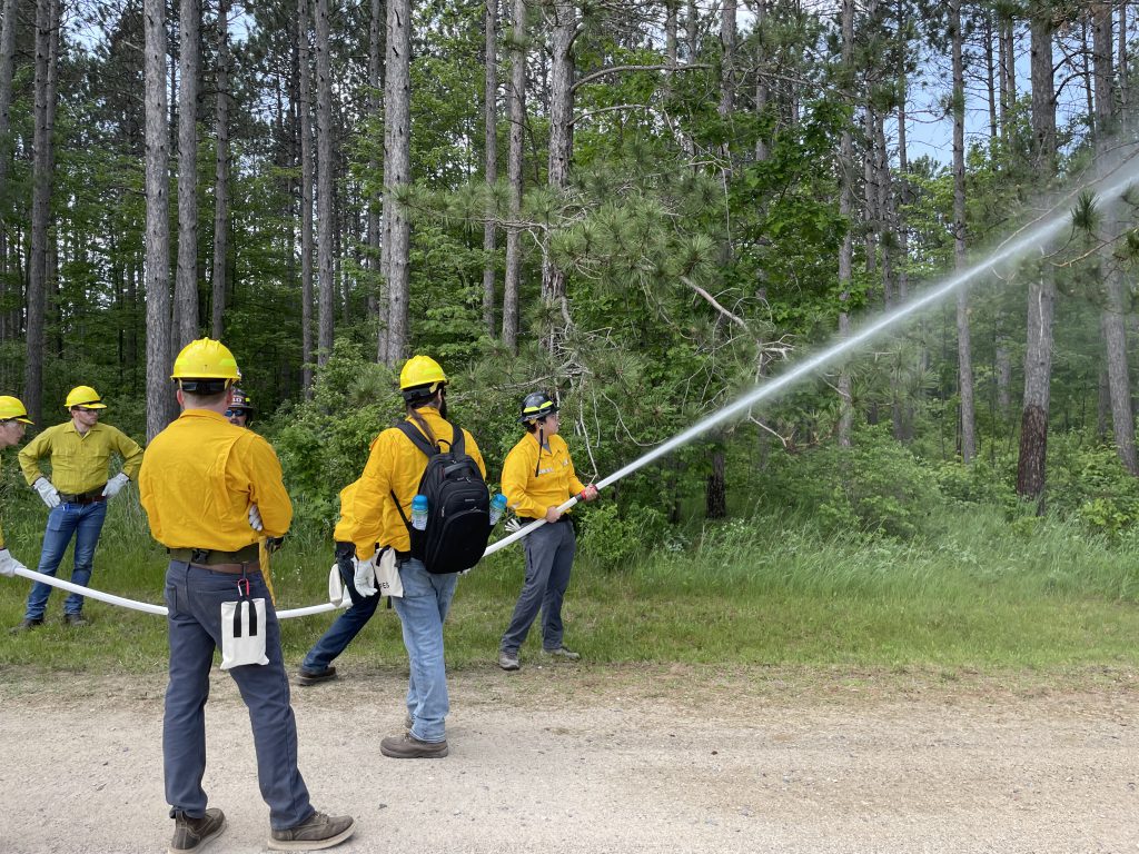 Wildfire Academy students using a fire hose