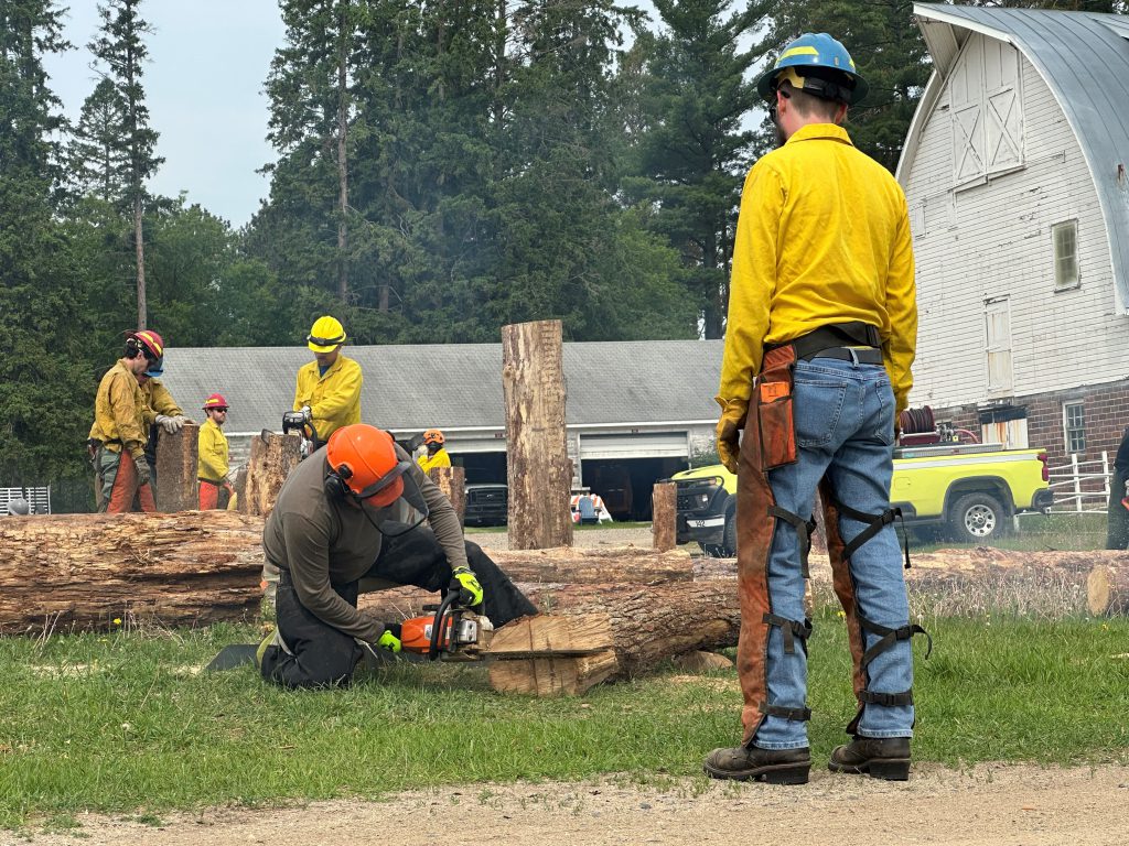 Class instructor watching a Wildfire Academy student use a chainsaw